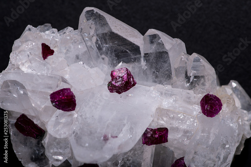 Top quality A grade small rough RUBY crystals from Tanzania on FADEN QUARTZ CLUSTER. Isolated on black background. photo
