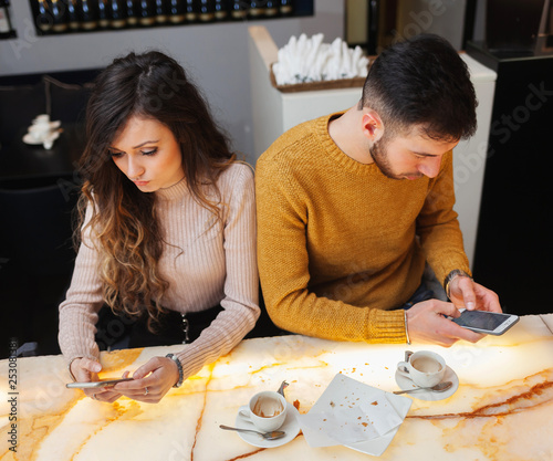 Young couple at the bar, asociality concept. photo