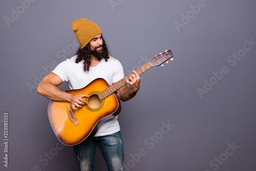 Portrait of his he nice handsome attractive cheerful confident wavy-haired guy playing guitar hit pop rock composition isolated over gray pastel background