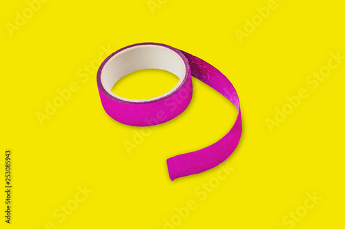 Roll of violet sticky tape in center on yellow background