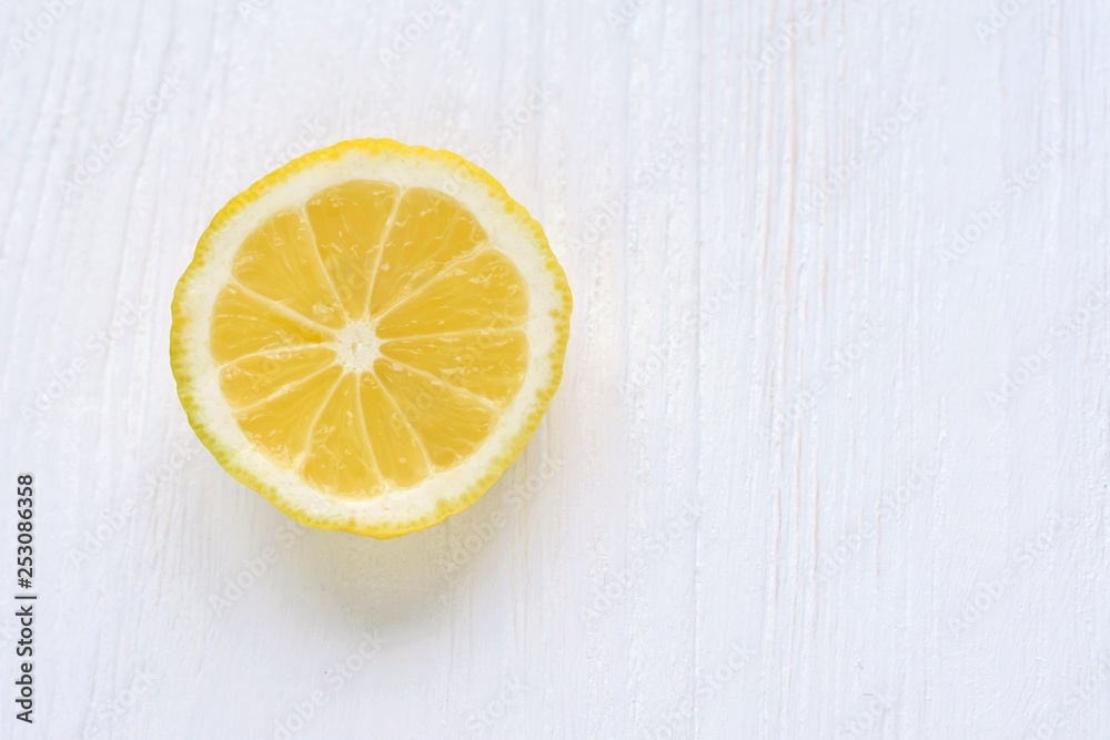 slice of juicy yellow lemon with selective focus on white wooden background. Fresh cutting organic lemon on blurred neutral backdrop. Citrus flat lay with empty space for text slice of juicy yellow lemon with selective focus on white wooden background. Fresh cutting organic lemon on blurred neutral backdrop. Citrus flat lay with empty space for text