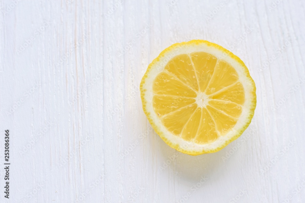 slice of juicy yellow lemon with selective focus on white wooden background. Fresh cutting organic lemon on blurred neutral backdrop. Citrus flat lay with empty space for text slice of juicy yellow lemon with selective focus on white wooden background. Fresh cutting organic lemon on blurred neutral backdrop. Citrus flat lay with empty space for text