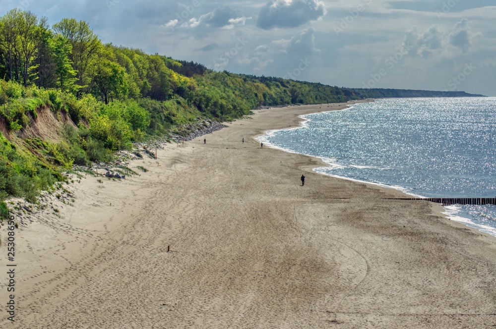 empty wide Baltic beach with a wooded coast, view from above of the town of Rewal