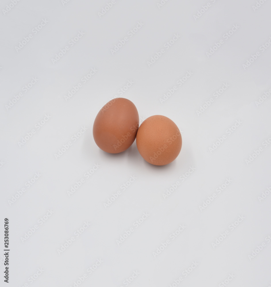 Two  brown eggs together on the grey background