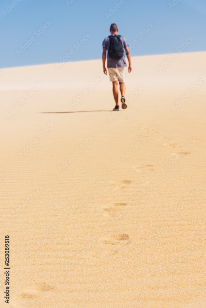 young backpacker man walking by the desert