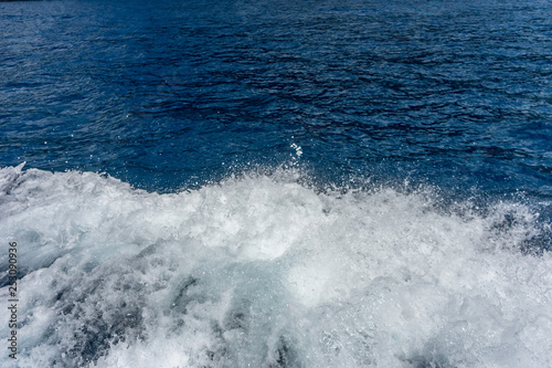 Italy, Cinque Terre, Monterosso, a man riding a wave on top of a body of water