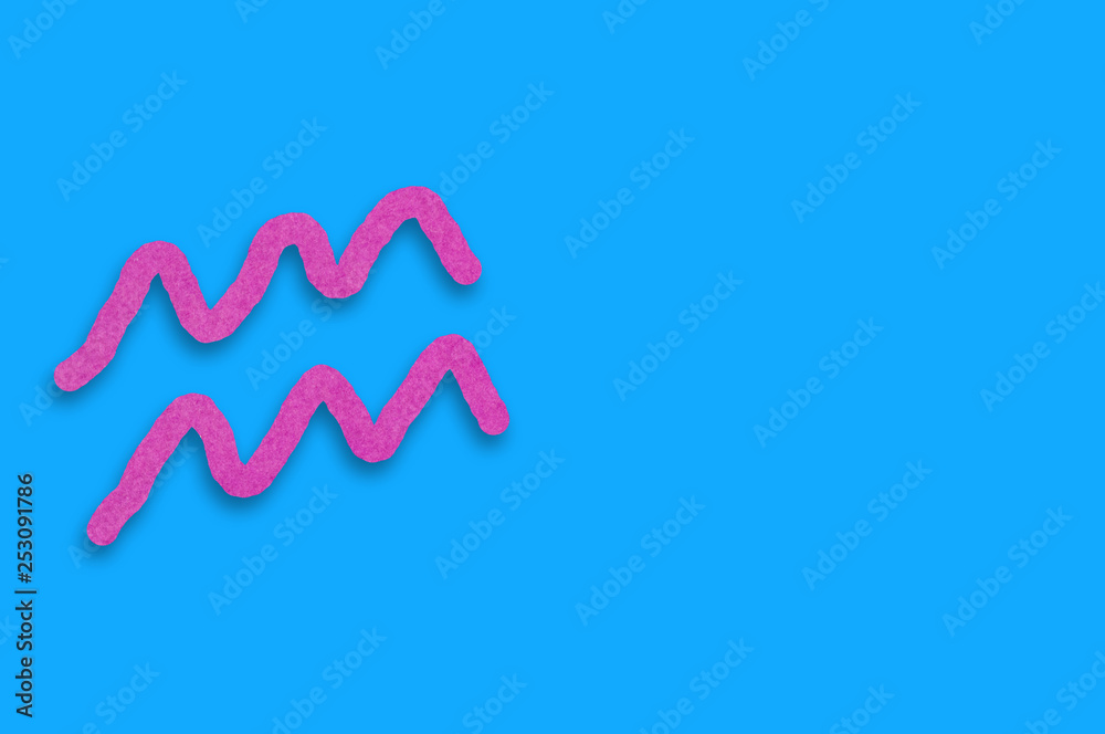 Symbol of astrological sign aquarius cut out of purple paper on blue table. Top view. Horoscope concept. Copy space for your text Symbol of astrological sign aquarius cut out of purple paper on blue table. Top view. Horoscope concept. Copy space for your text