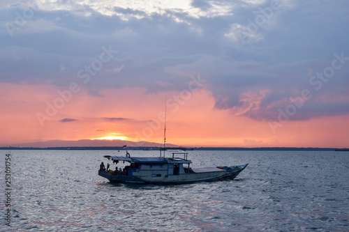 boat on beach at sunset © Wartono