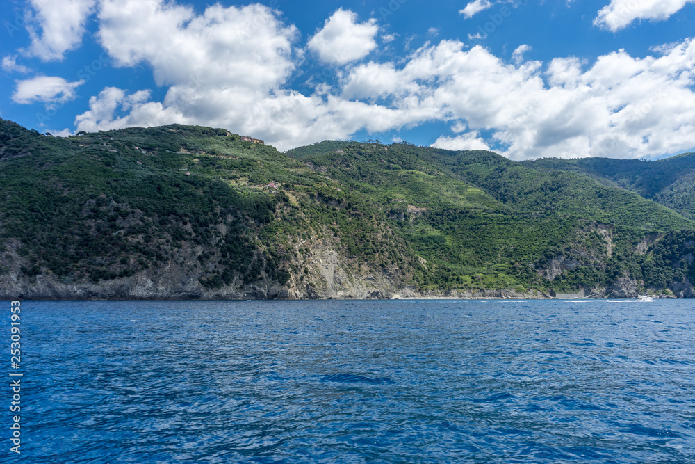 Italy, Cinque Terre, Monterosso, a large body of water with a mountain in the background Italy, Cinque Terre, Monterosso, a large body of water with a mountain in the background