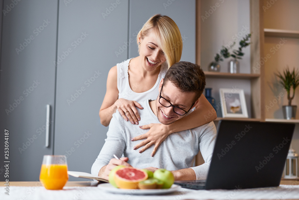 Cheerful woman hugging man making notes Cheerful woman hugging man making notes