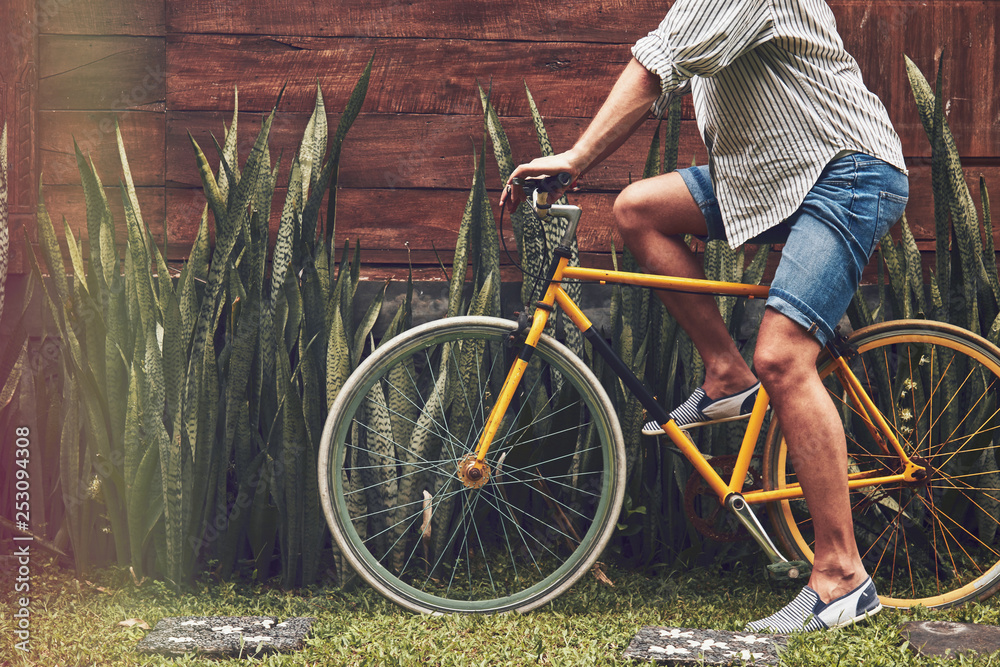 Naklejka premium Attractive man standing with old bicycle.