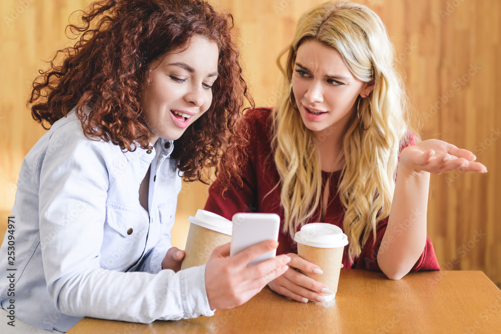beautiful women holding paper cups and smartphone at cafe beautiful women holding paper cups and smartphone at cafe