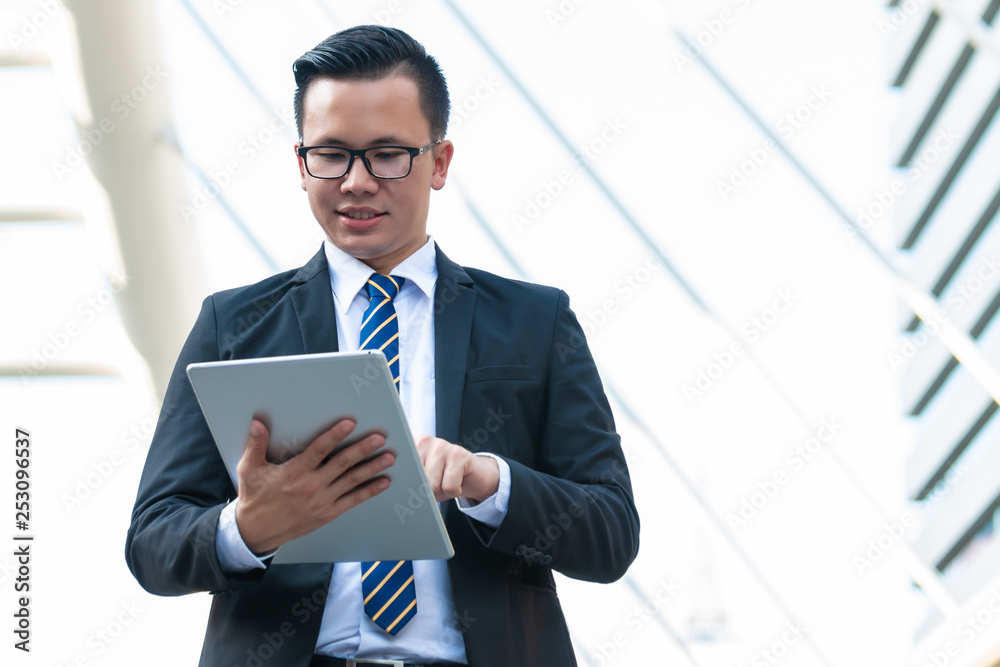 Happy businessman dressed in black suit outside office and smile. Digital technology concept. Happy businessman dressed in black suit outside office and smile. Digital technology concept.