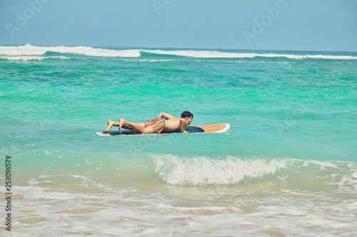 Surfer man with surfboard enjoying on the beach. Summer concept. © Kitja