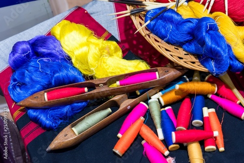 A closeup image of an old weaving Loom and thread of yarn.