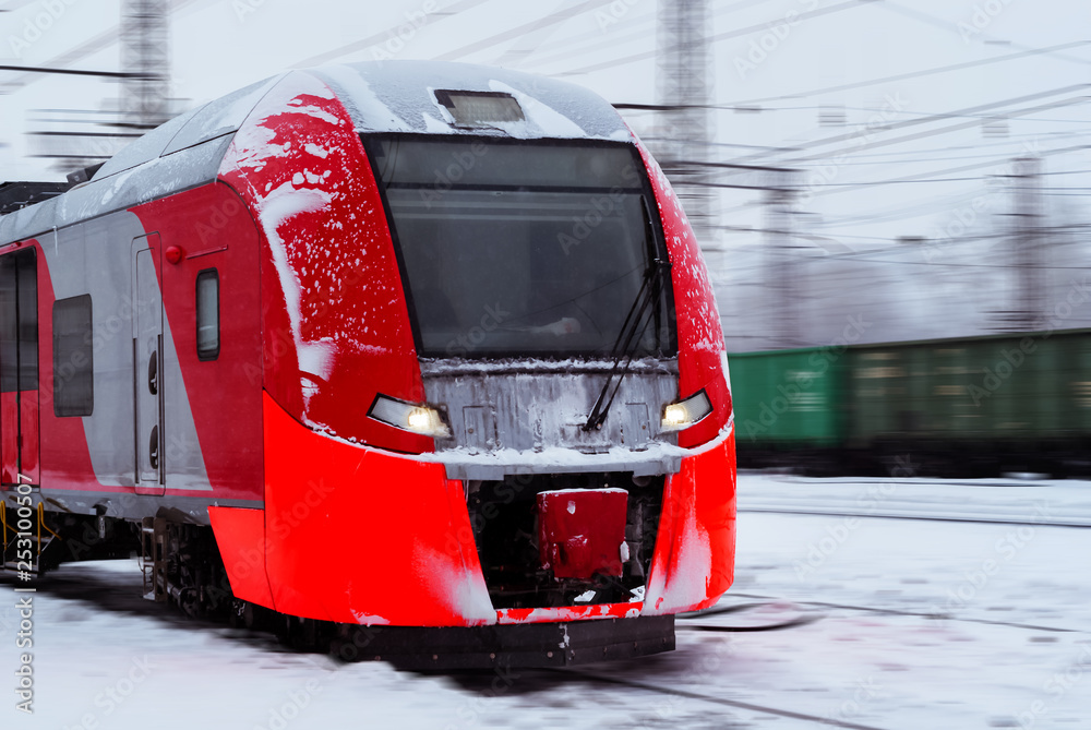 Fototapeta premium ice-covered multiple-unit train rides by rail in winter
