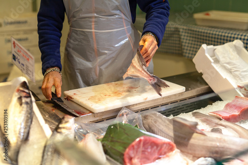 vendor cutting fish. A typical scene at the traditional fish market
