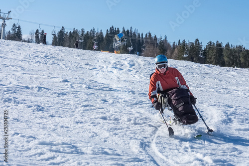 person with a disability,  snow sports, handicapped athlete goes downhill skiing, disabled skier and adaptive Winter Sports, handicapped person and mono-skiing