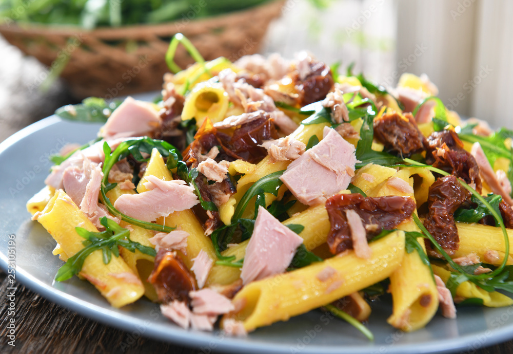 Penne pasta with tuna chunks, rucola and dry tomatoes Penne pasta with tuna chunks, rucola and dry tomatoes