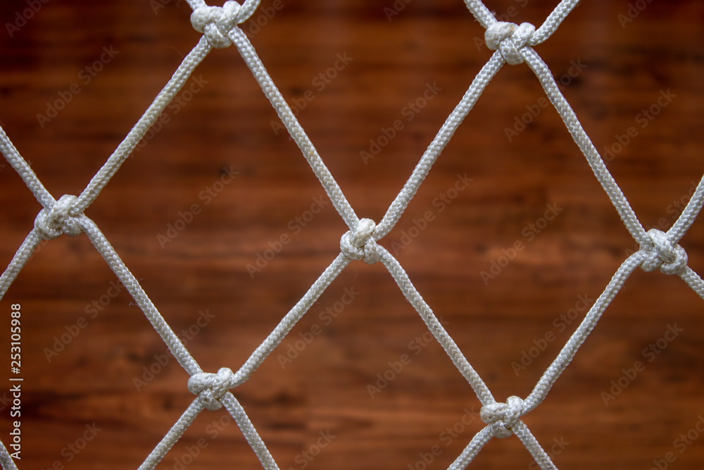 Rope net from a hammock, against a wooden laminate