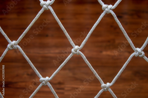 Rope net from a hammock, against a wooden laminate