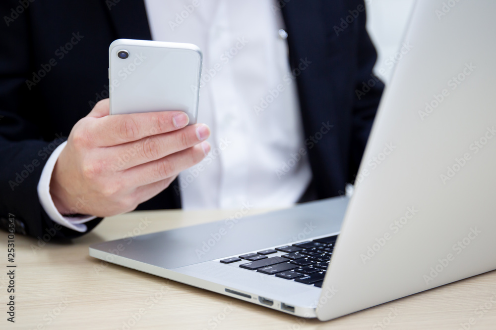 Business man in formal black suit checking a message on a smartphones. Business man in formal black suit checking a message on a smartphones.