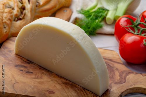 Italian cheese, Provolone dolce cow cheese from Cremona served with olive bread and tomatoes