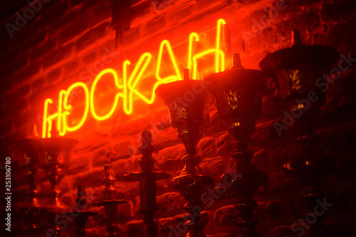line of hookas at red light background. neon hookah sighnboard