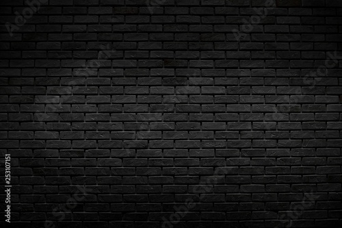The old vintage black bricks wall with lighting decoration in dark tone style on architecture and background design concept