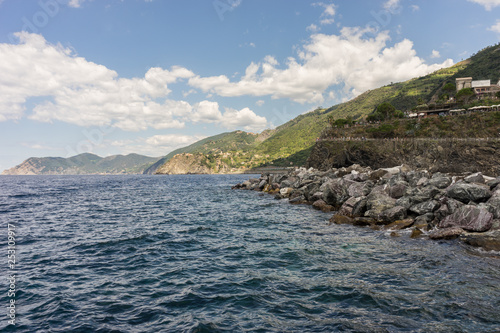 Italy  Cinque Terre  Monterosso  a large body of water with a mountain in the background