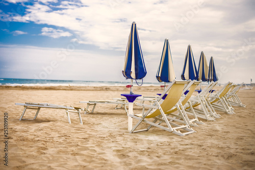 sunny italy sand beach. Adriatic sea riviera. Blue and yellow deck chairs. nobody. © darkside17