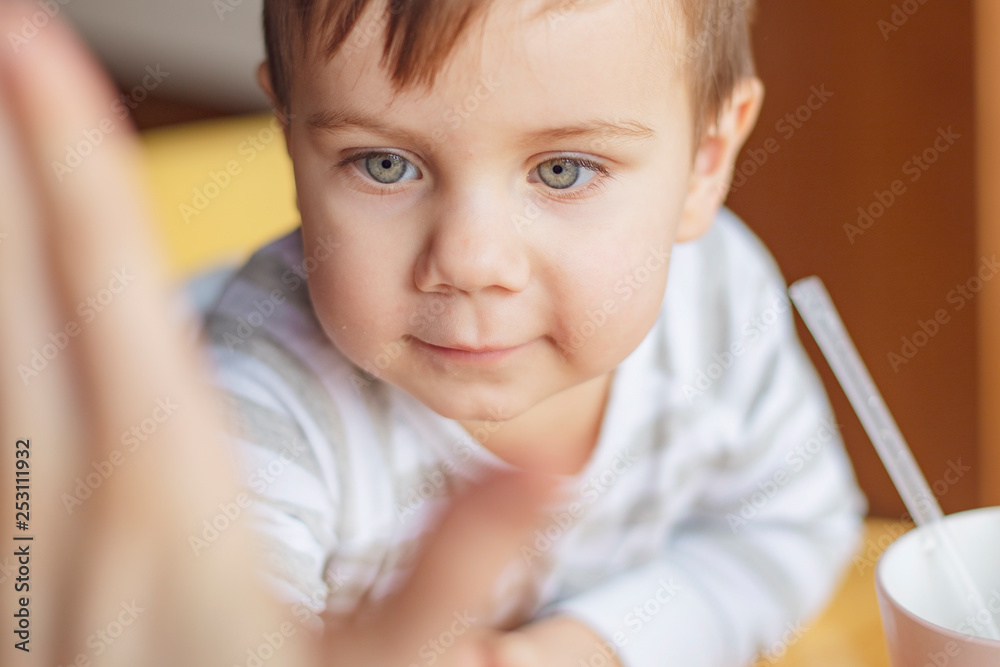 A little boy clapping his mother or his father in a palm, a photo from the first person. The boy gives his hand five to the friends opposite. Give me five A little boy clapping his mother or his father in a palm, a photo from the first person. The boy gives his hand five to the friends opposite. Give me five