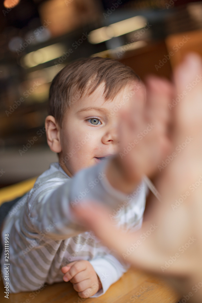 happy family, blonde mother and her beautiful and charismatic little son, the boy is having fun day in a cozy cafe. selective focus, noise effect happy family, blonde mother and her beautiful and charismatic little son, the boy is having fun day in a cozy cafe. selective focus, noise effect
