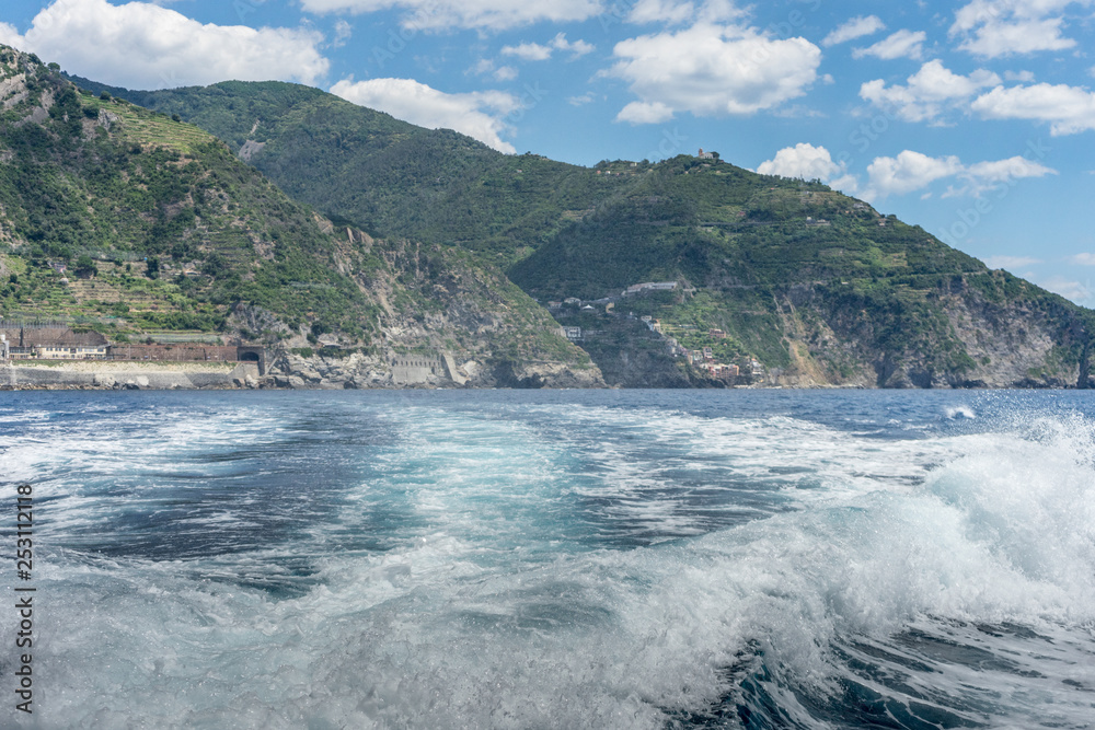 Italy, Cinque Terre, Monterosso, a body of water with a mountain in the middle of a wave