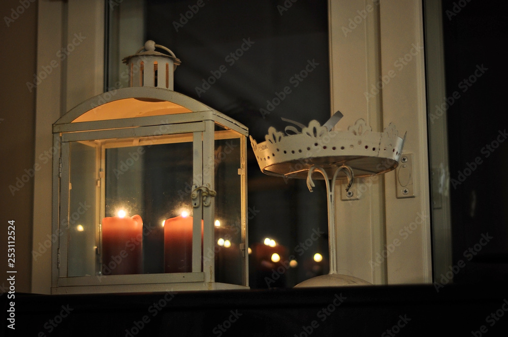 Two Christmas candles on a window in the evening. A traditional Scandinavian Christmas decoration style during dark Winter season.