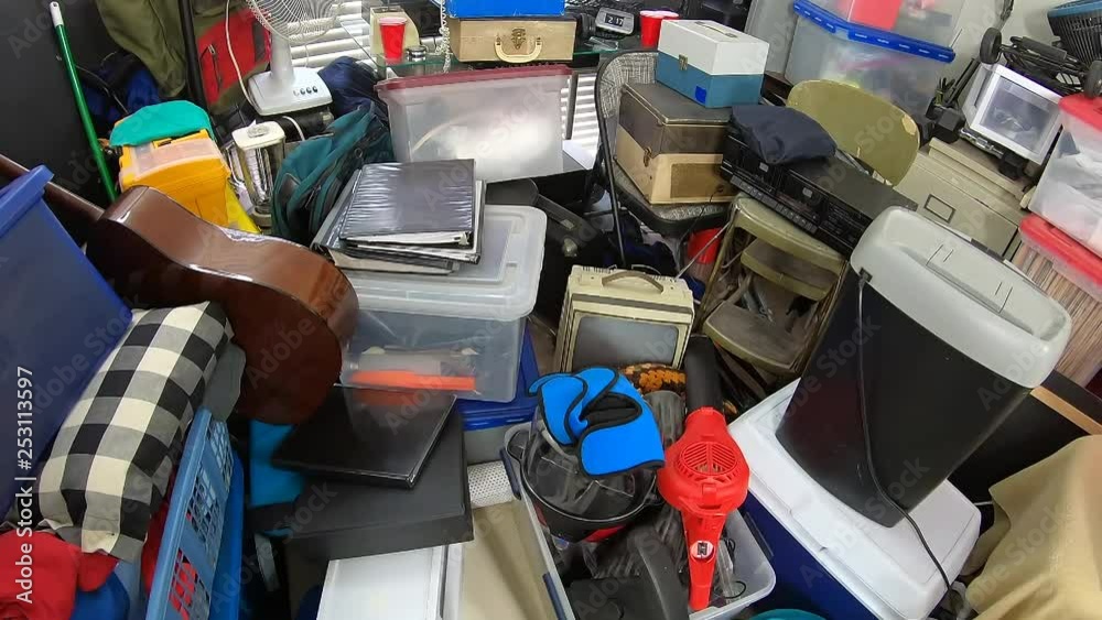 Cluttered hoarder room.  Slow dolly out over piles of household items, vintage electronics, business equipment and miscellaneous junk.