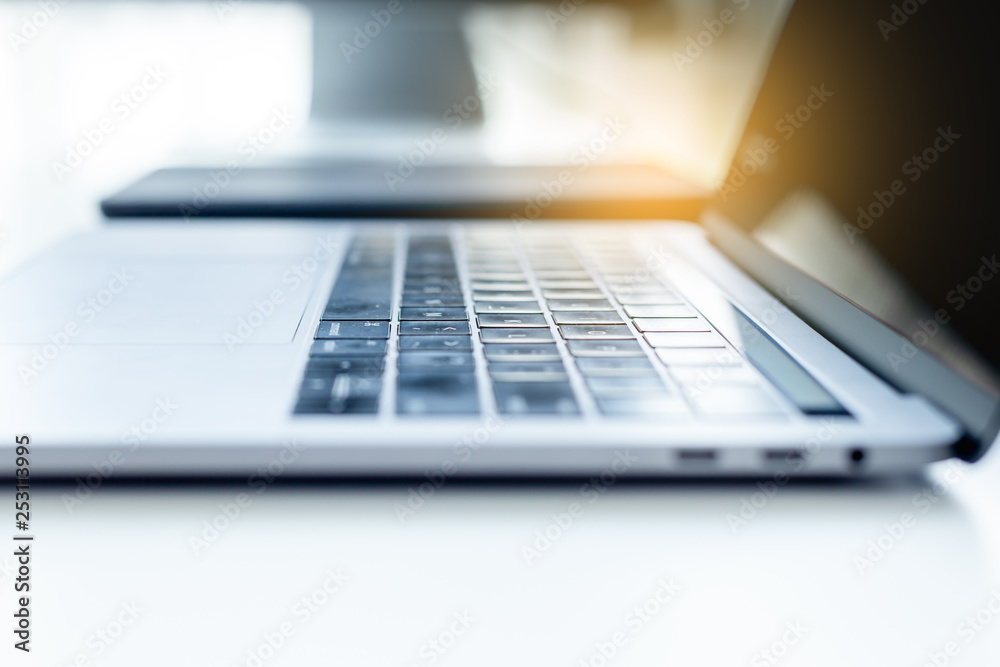 Close up view workspace with desktop computer office , laptop on white table with sunlight Close up view workspace with desktop computer office , laptop on white table with sunlight
