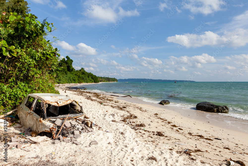 Pollution on the beach of tropical sea. Plastic garbage, car wreck, wood and dirty waste on beach in summer day. Pollution on the beach of tropical sea. Plastic garbage, car wreck, wood and dirty waste on beach in summer day.