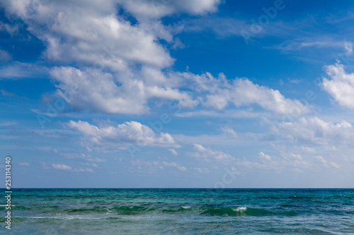 Seascape with clouds hanging over calm sea in calm weather. Tropical horizontal composition