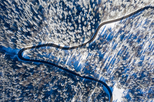 Curvy road in winter forest, view from above © savcoco