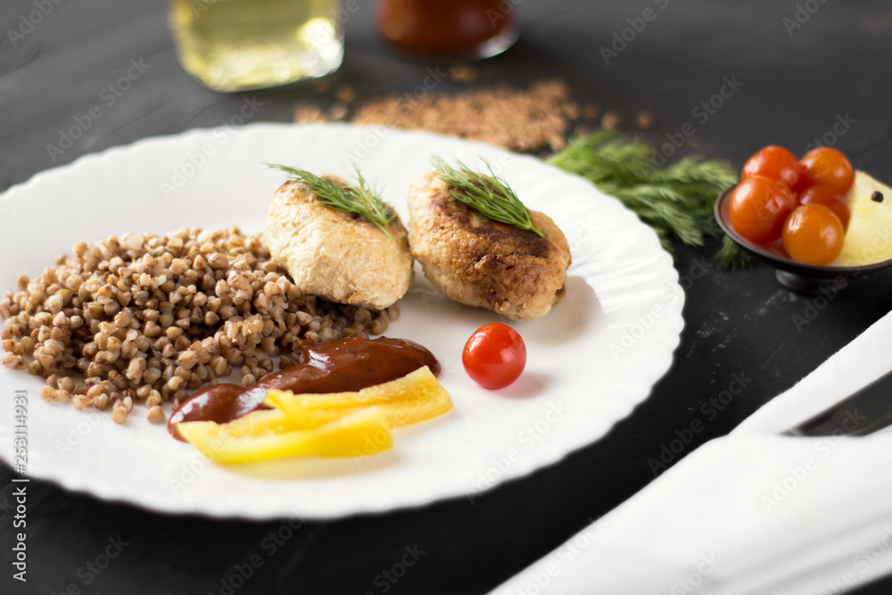 Chicken cutlets with buckwheat, herbs, ketchup and tomatoes