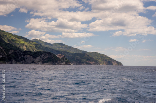 Italy  Cinque Terre  Monterosso  a large body of water with a mountain in the background