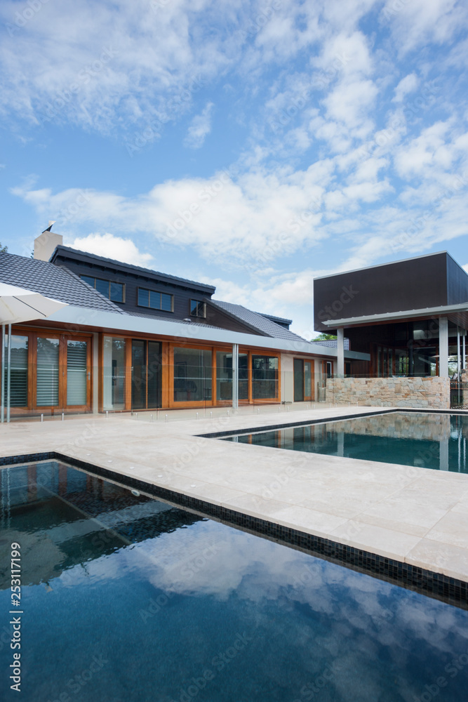 Modern mansion in front of swimming pool with blue sky