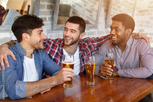 Best friends meeting and drinking beer in bar
