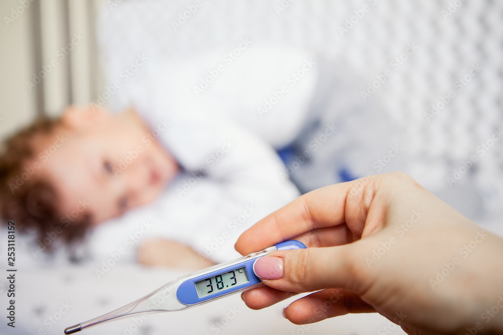 Naklejka premium flu epidemic. Close-up of a high-temperature thermometer. sick kid