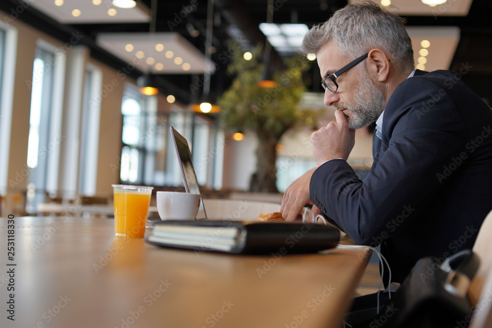 Businessman working in modern office cafeteria