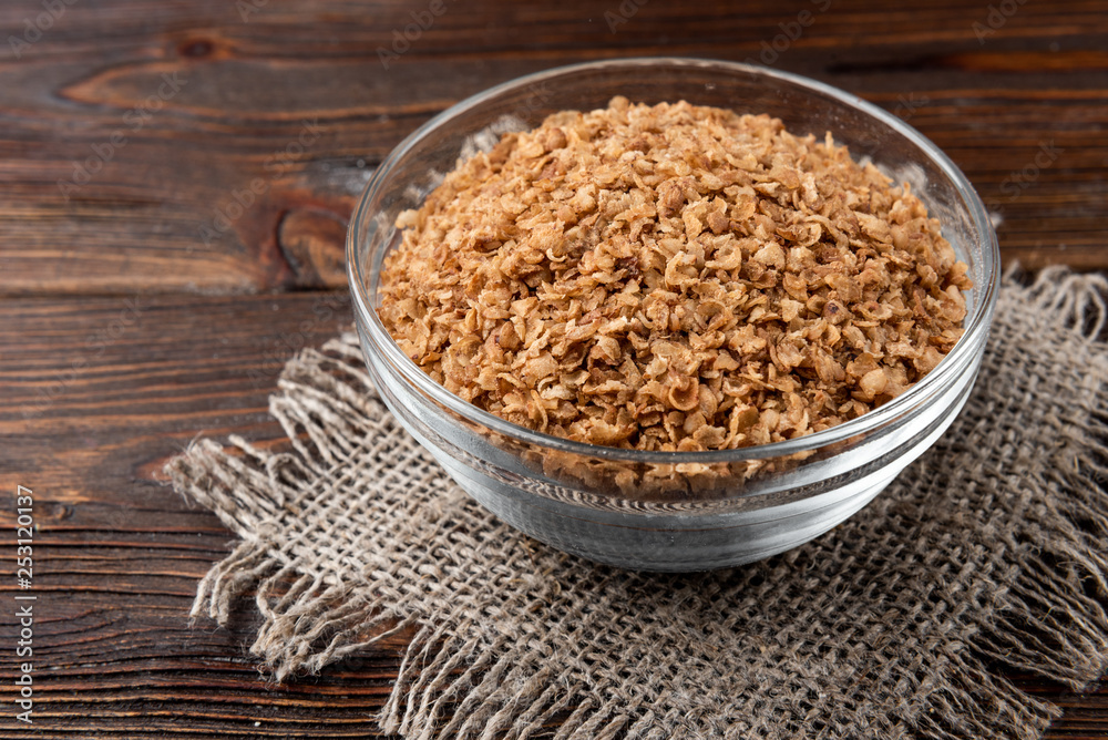Buckwheat flakes on dark wooden background. Buckwheat flakes on dark wooden background.