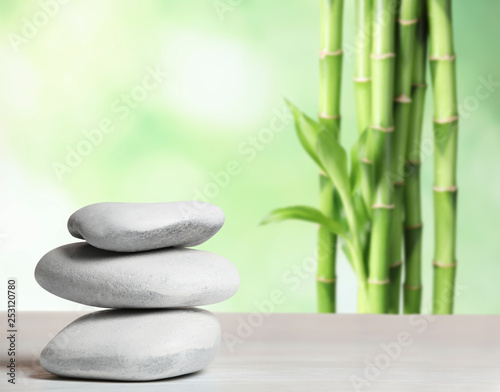 Spa stones on table against blurred background. Space for text