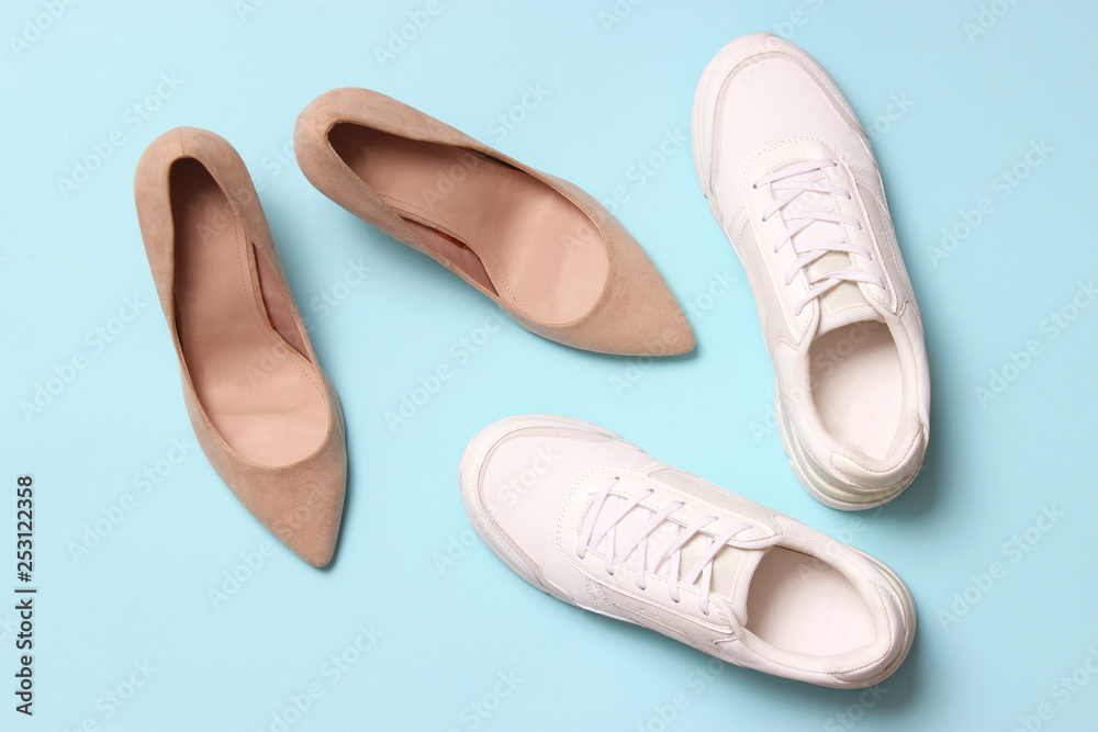 white sneakers and high heel shoes on a colored background top view. Women's shoes. Classic and sport shoes. white sneakers and high heel shoes on a colored background top view. Women's shoes. Classic and sport shoes.