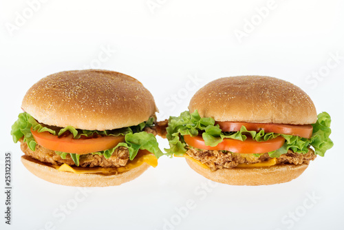 tasty unhealthy chicken burgers isolated on white